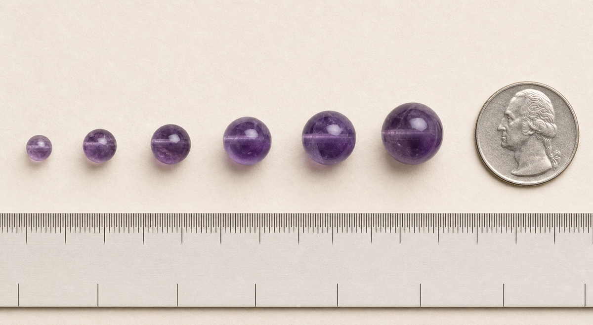 Six real amethyst beads increasing from 6 to 16 millimeters beside a US quarter and ruler